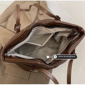 Detail view of brown tote bag interior with grey herringbone lining and zipper pocket