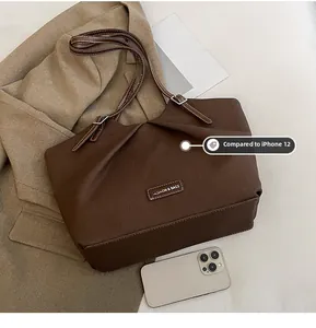 Detailed close-up of dark brown pleated tote bag texture compared with a smartphone