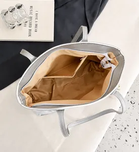 Interior view of the spacious grey tote bag featuring a brown lining and a zippered pocket