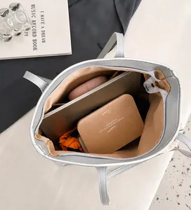 Interior view showing the large capacity of the silver tote bag with various daily items