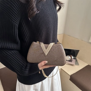 Elegant champagne box clutch bag with sunburst texture and V-shaped rhinestone buckle