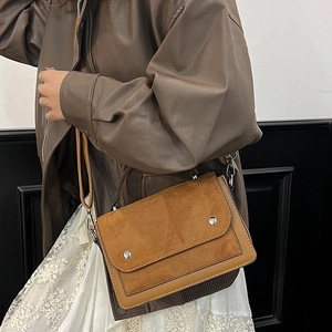 Minimalist earth-tone crossbody bag featuring a two-tone suede and leather flap design