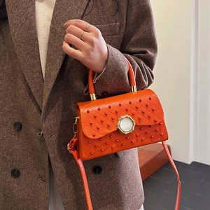 Sac bandoulière orange vif matelassé avec perles et boucle dorée circulaire