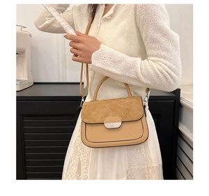 Chic two-tone saddle bag with suede flap and metal buckle worn with a lace dress