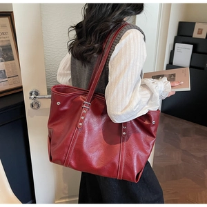 Detail view of the vintage dark red tote bag with contrast stitching and metal rivets