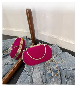 Detail of fuchsia velvet evening bag with gold bow clasp and metallic chain strap