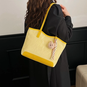 Retro yellow tote bag with bear charm pendant and spacious interior for daily commute