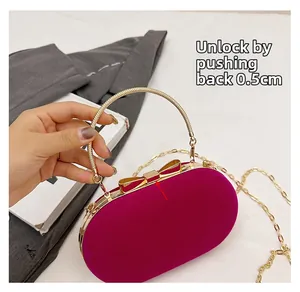 Detail showing how to open the fuchsia velvet handbag bow clasp by pushing back 0.5cm
