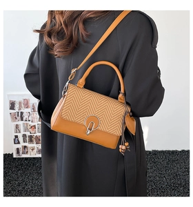 Bolso pequeño marrón con diseño de espiga, hebilla plateada y colgante de cuentas de madera