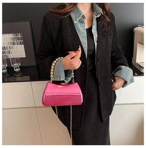 Detail of hot pink metallic box bag with gold beaded handle and chain strap