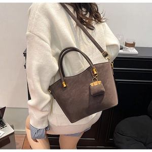 Detail of coffee brown matte leather tote bag with gold hardware and mini pouch