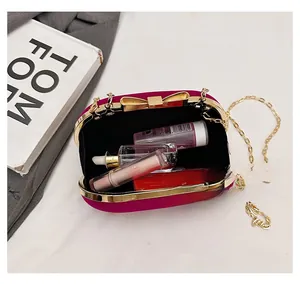 Detail view of pink velvet evening bag interior showing capacity for cosmetics and chain