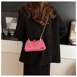 Detail of metallic pink box bag with large gold bead handle and fine chain strap