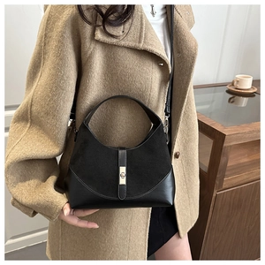 Dettaglio borsa hobo nera in pelle e scamosciato con chiusura a rotazione dorata