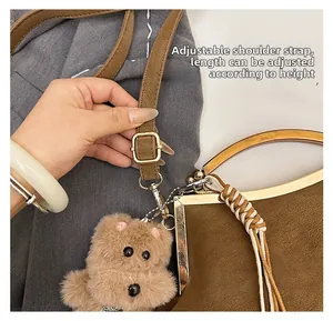Détail de la bandoulière réglable en cuir marron avec boucle dorée sur sac vintage