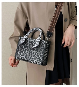 Detail of leopard print handbag with a silk scarf handle and wide jacquard shoulder strap