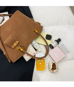 Detailed top view of large capacity brown suede tote bag showing daily essentials inside