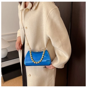 Detail of blue mirror evening bag with gold beaded handle and metal chain strap