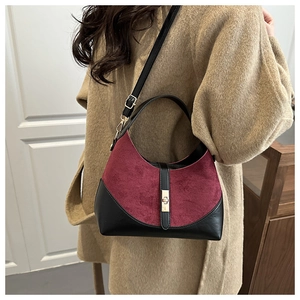 Dettaglio della borsa hobo in pelle scamosciata bordeaux e nera con fibbia dorata
