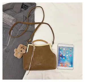 Vue détaillée du sac docteur vintage marron avec cadre en métal et breloque en peluche