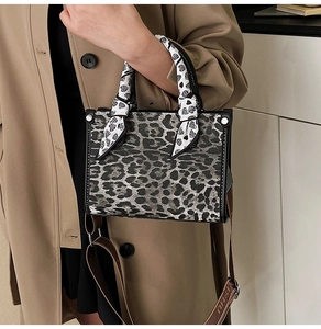 Detail of leopard print handbag with heart pattern scarf wrap and woven shoulder strap