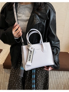 Close-up of lilac striped tote bag with fashion letter strap on a leather jacket