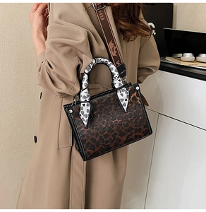 Detail of leopard print handbag with silk scarf handle and stylish jacquard strap