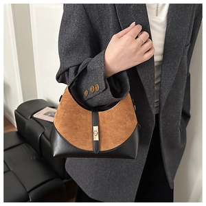 Detail of contrast leather and suede crossbody bag with gold buckle hardware