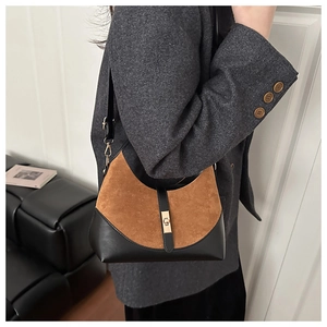 Dettaglio borsa hobo in pelle scamosciata marrone e nera con chiusura in metallo oro