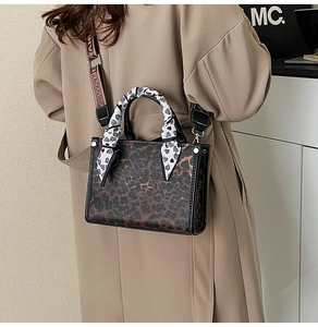 Close-up of leopard print handbag with silk scarf handle and wide jacquard shoulder strap