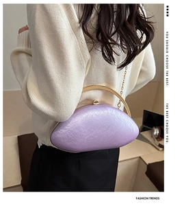 Detail view of purple oval acrylic evening bag with gold metal handle and chain strap
