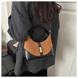 Dettaglio borsa vintage in pelle scamosciata marrone e nera con fibbia dorata metallica