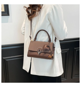 Bolso bandolera marrón con solapa de espiga y colgante de cuero en forma de corazón