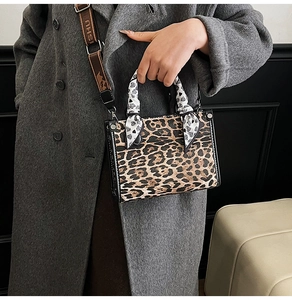 Detail of leopard print handbag with silk scarf handle and logo canvas shoulder strap