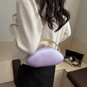 Detailed texture of light purple acrylic evening bag with gold handle and chain strap