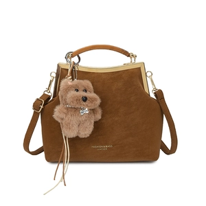 Sac vintage caramel avec poignées ambre et charm chien en peluche sur fond blanc