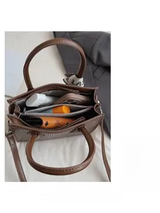 Top view of brown shoulder bag showing three spacious internal compartments for storage
