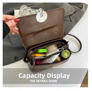 Vista interna con gran capacidad y compartimentos del bolso bandolera marrón