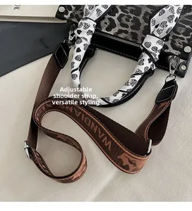 Detail view of leopard print handbag with heart pattern scarf and adjustable strap