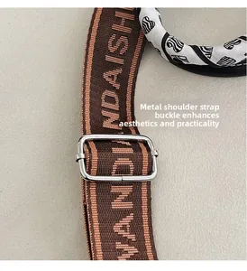Macro shot of brown woven shoulder strap with adjustable silver metal slider buckle