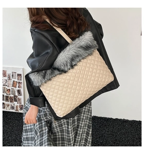 Detail of quilted beige tote bag with grey faux fur trim and leather shoulder strap