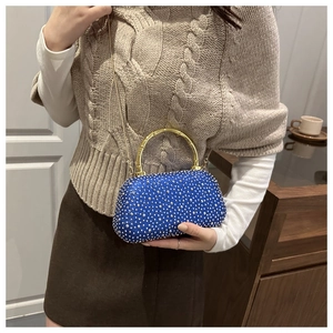 Detail of blue rhinestone evening bag with gold bamboo handle and chain strap