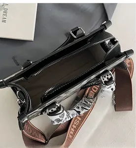 Interior view of black tote bag showing zipper compartment and decorative heart scarf