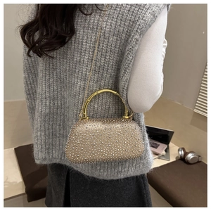 Detail of champagne gold evening bag with rhinestones and bamboo handle link