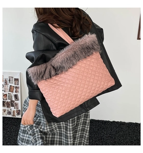 Detail of pink quilted tote bag with gray faux fur trim and diamond stitch texture