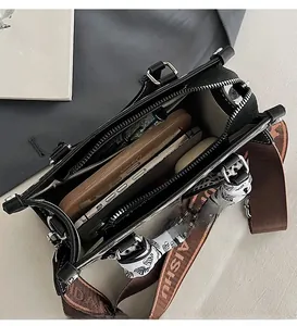 Interior view of black pebble leather handbag with large capacity and floral scarf detail