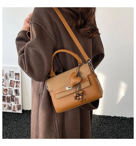 Brown vintage handbag with houndstooth pattern shown on person in dark wool coat
