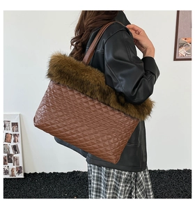 Detail of plush tote bag with diamond quilting and faux fur trim on a model