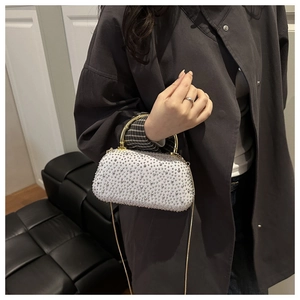 Detail of a sparkling rhinestone evening bag with gold metal handle and chain strap