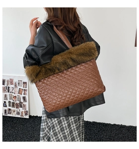 Detail of brown quilted tote bag with faux fur trim worn by a model in black leather jacket